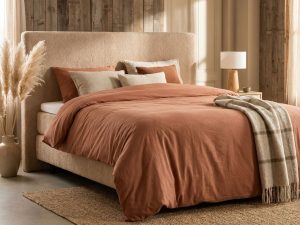 Luxe boxspring met beige teddy hoofdbord, terracotta dekbed en natuurlijke styling in warme slaapkamer