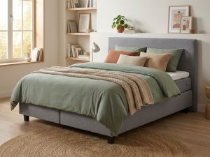 Complete boxspring met grijs gestoffeerd frame en saliegroen dekbed in moderne tienerslaapkamer met natuurlijke belichting