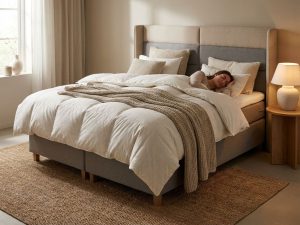 Complete boxspring bed voor twee personen in beige slaapkamer met bewegingsisolatie demonstratie en zachte verlichting