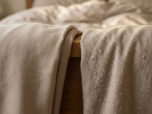 Close-up vergelijking van hoogwaardige lakens: gladde katoen zonder pilling versus stof met zichtbare pilling